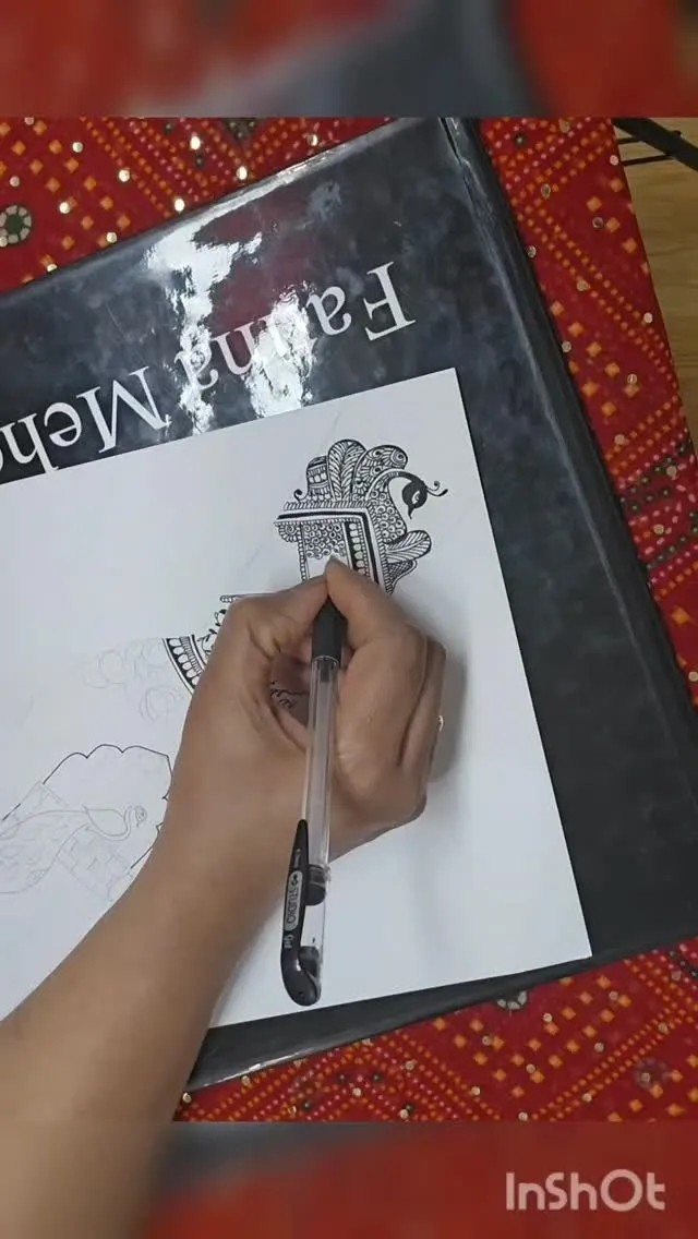 Student practising a henna design on paper during the course