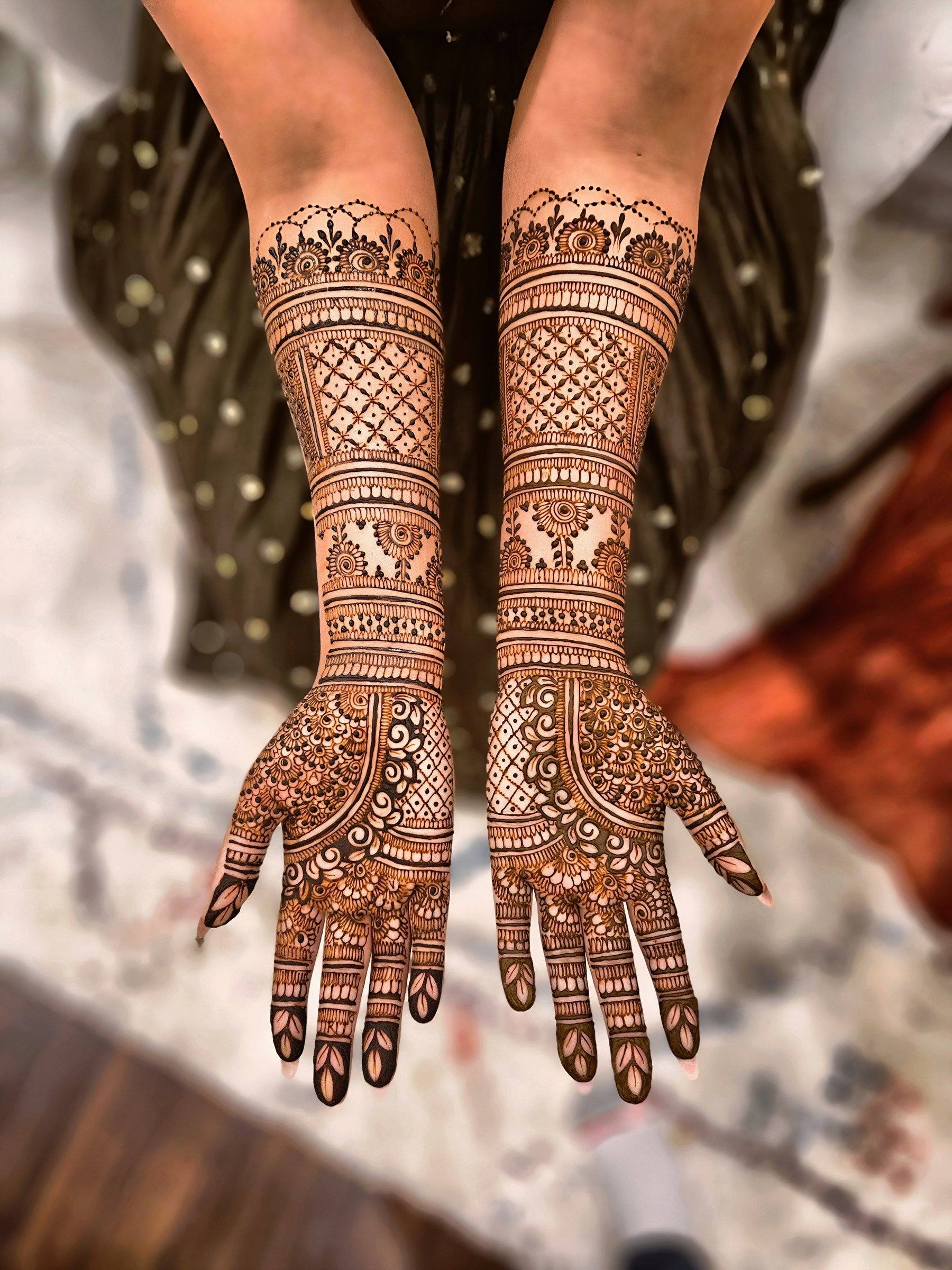 Bridal henna on both arms with lattice and floral bands