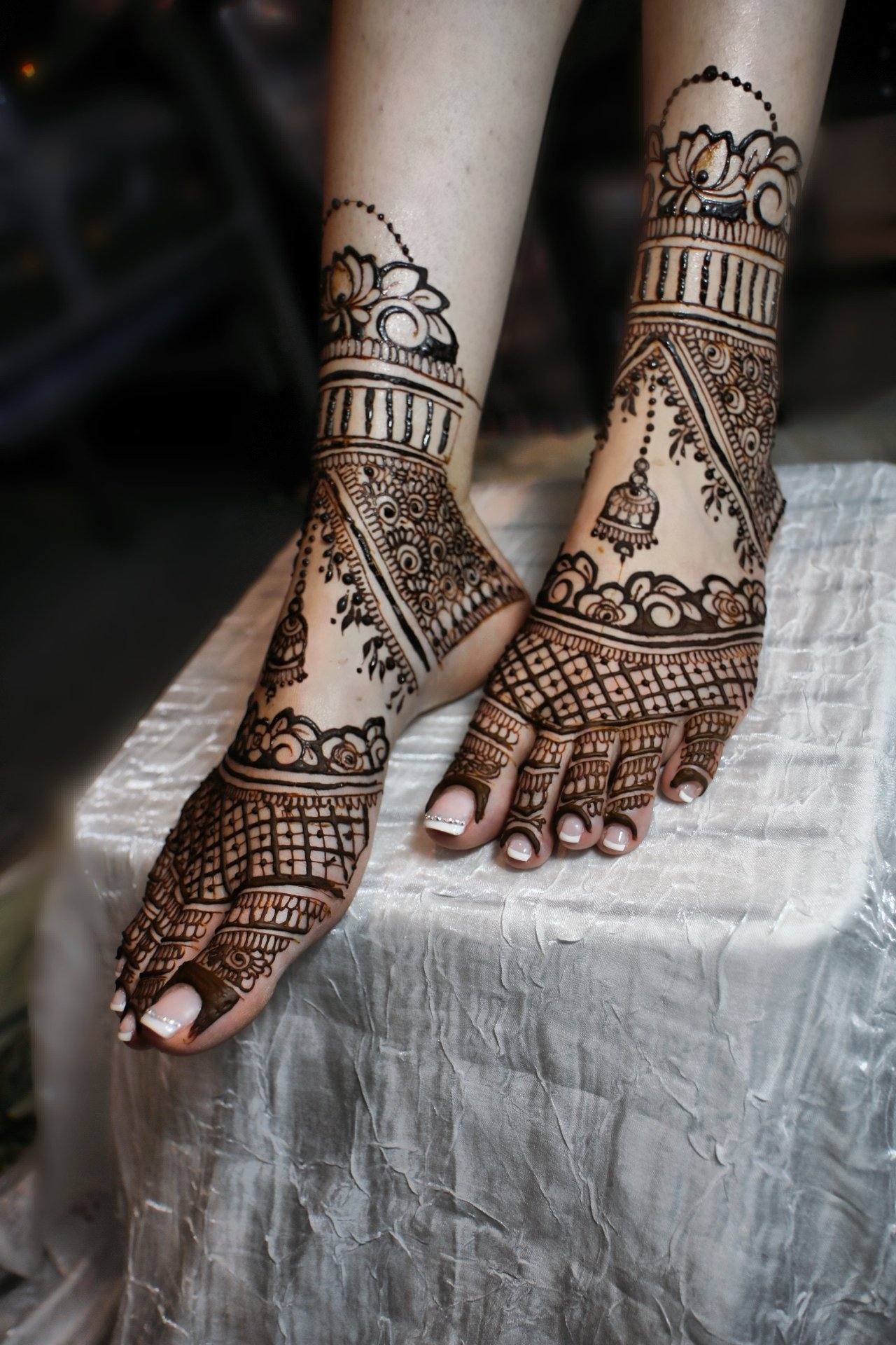 Bridal henna feet resting on draped fabric