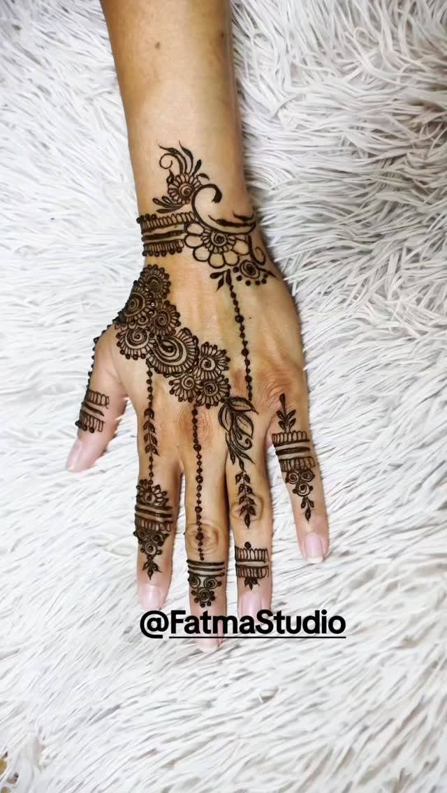 Light, airy henna on the back of the hand with a floral wrist band and fine dotted lines down the fingers