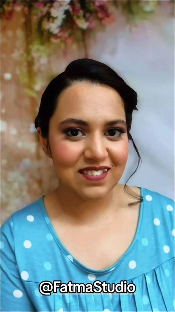 Fresh, natural makeup with a sleek updo on a blue outfit
